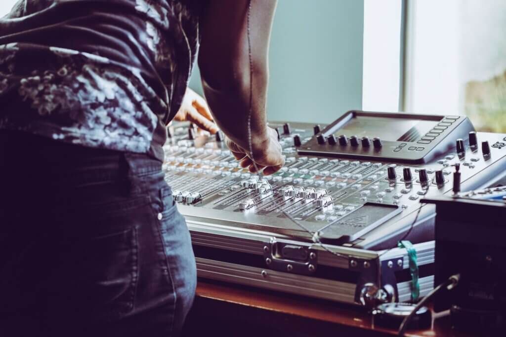 photo of person adjusting audio mixer How to DJ Like a Pro: Picking the Perfect Playlist and Speakers for Your Party